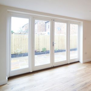 The interior of a home with four panels of glass patio doors with white frames